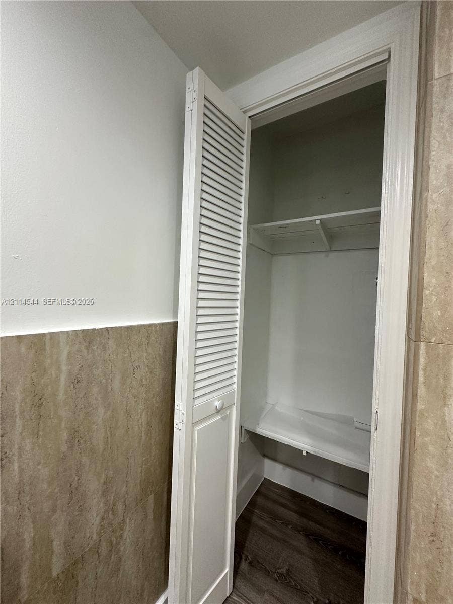 1413 N Dixie Highway, #3, Fort Lauderdale, Fort Lauderdale, FL 33304 Closet featuring white louvered bi-fold doors, interior shelving, and wood-finish flooring