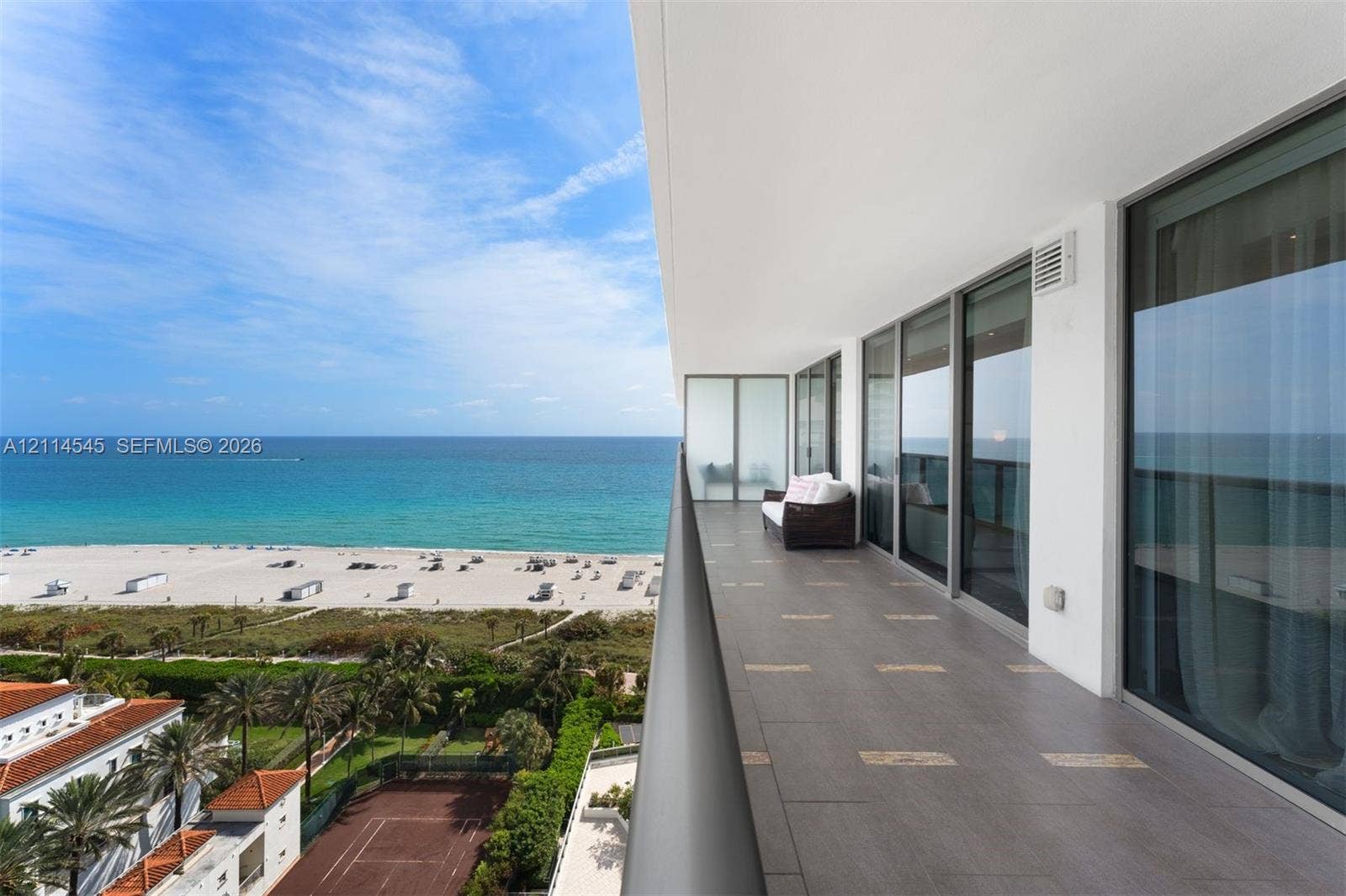 5875 Collins Avenue, #1503, Miami Beach, FL 33140 Expansive balcony with large-format tile flooring, metal railing, and floor-to-ceiling glass sliding doors