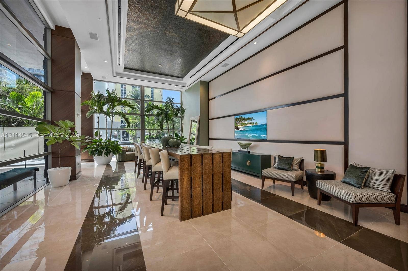 5875 Collins Avenue, #1503, Miami Beach, FL 33140 Grand lobby featuring floor-to-ceiling windows, polished stone flooring, a textured recessed ceiling with geometric lighting, and decorative wall paneling
