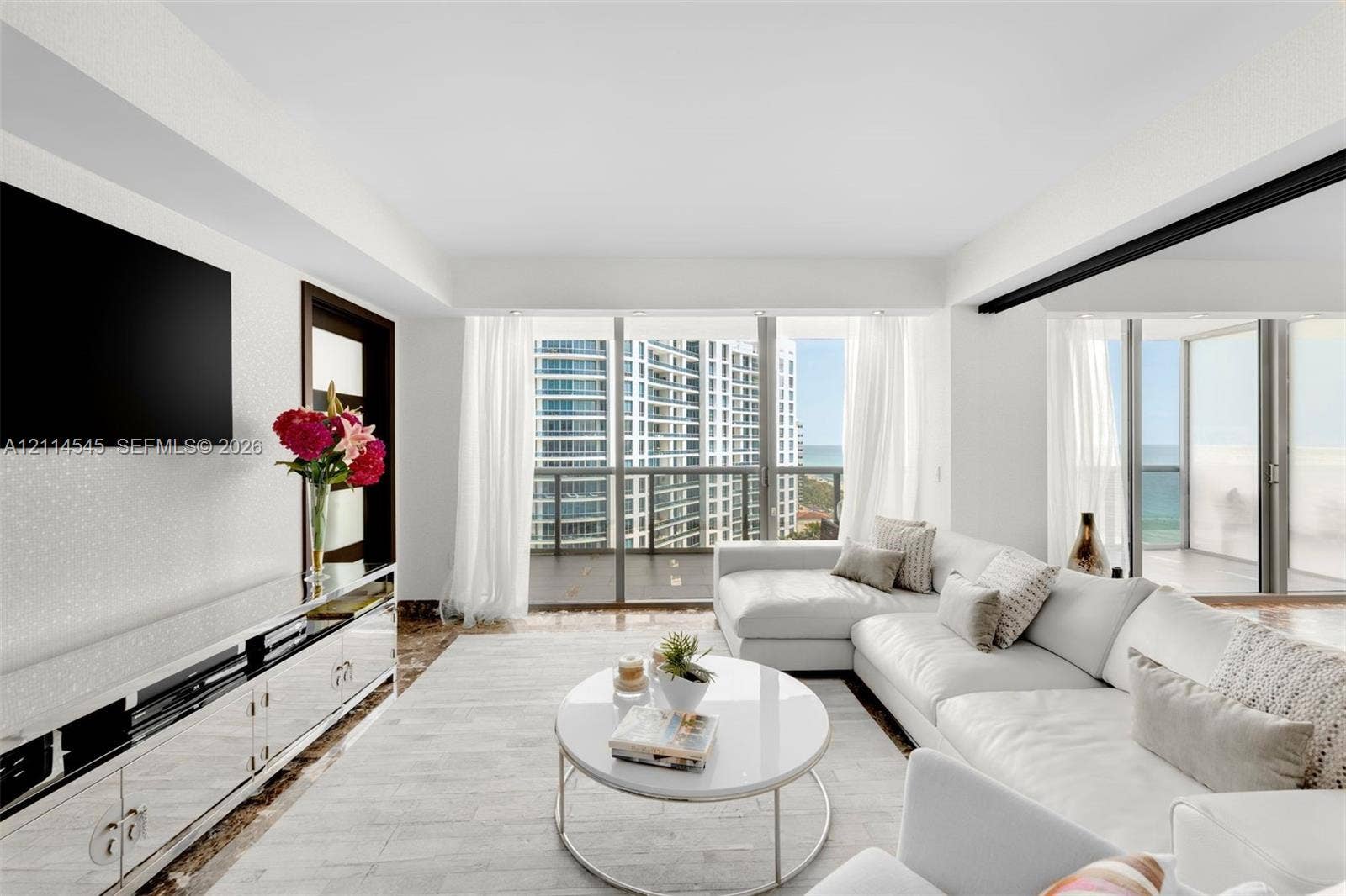 5875 Collins Avenue, #1503, Miami Beach, FL 33140 Open-concept living area featuring floor-to-ceiling glass windows, polished stone flooring, and a private balcony