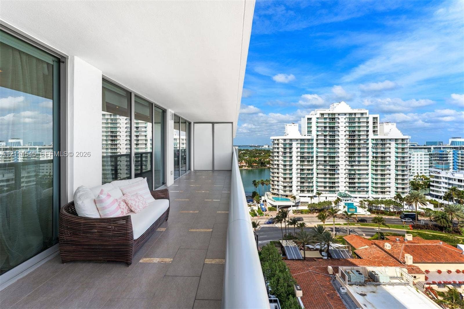 5875 Collins Avenue, #1503, Miami Beach, FL 33140 Expansive covered balcony featuring large-format ceramic tile flooring, a minimalist metal railing, and floor-to-ceiling glass sliding doors