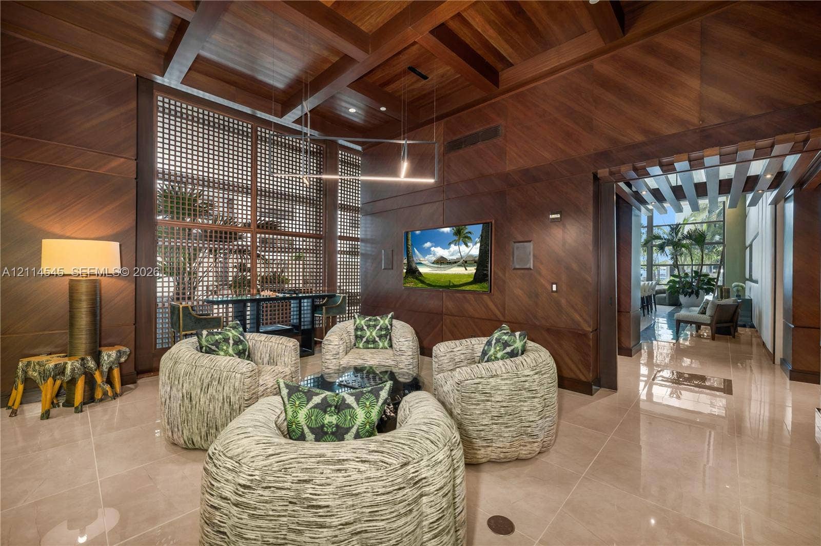 5875 Collins Avenue, #1503, Miami Beach, FL 33140 Custom wood-paneled walls and ceiling featuring exposed beams, stone-finish flooring, floor-to-ceiling latticed window detailing, and recessed lighting