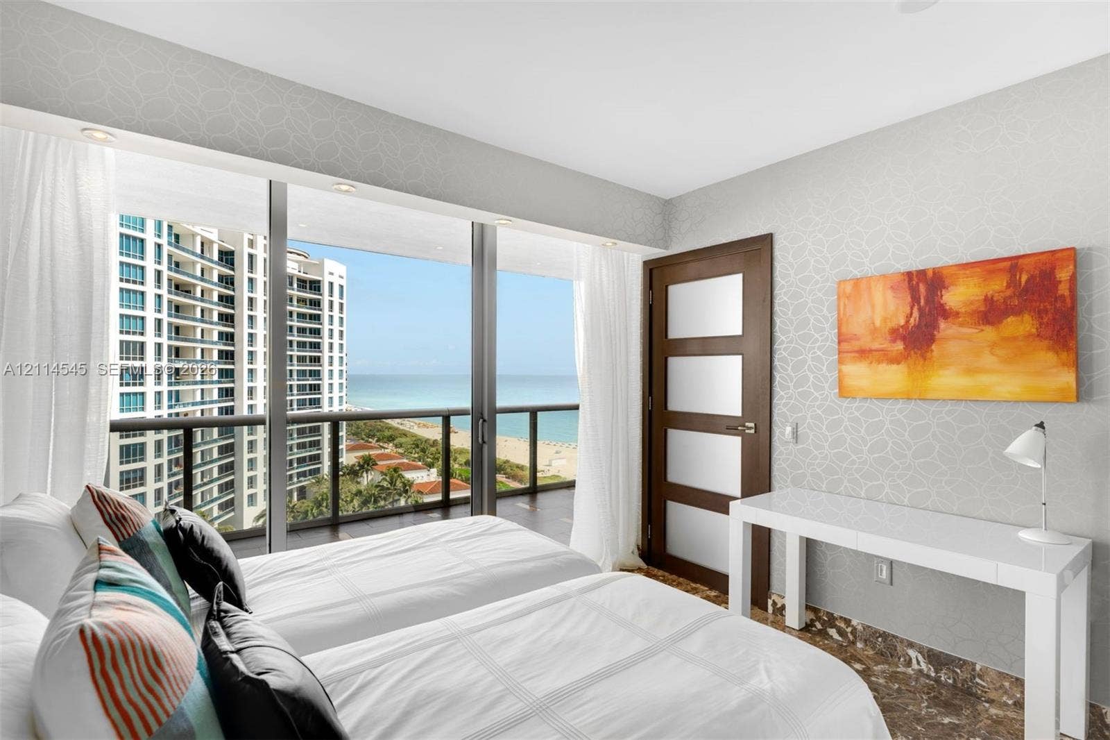 5875 Collins Avenue, #1503, Miami Beach, FL 33140 Floor-to-ceiling glass sliding doors, private balcony with metal railing, oceanic scenery, patterned wall covering, and stone-finish flooring