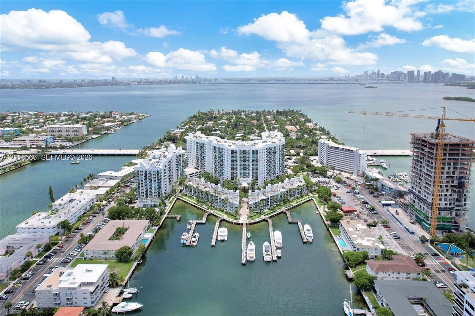Aerial perspective of waterfront multi-family residential structures featuring direct canal access, private boat slips, and coastal landscaping