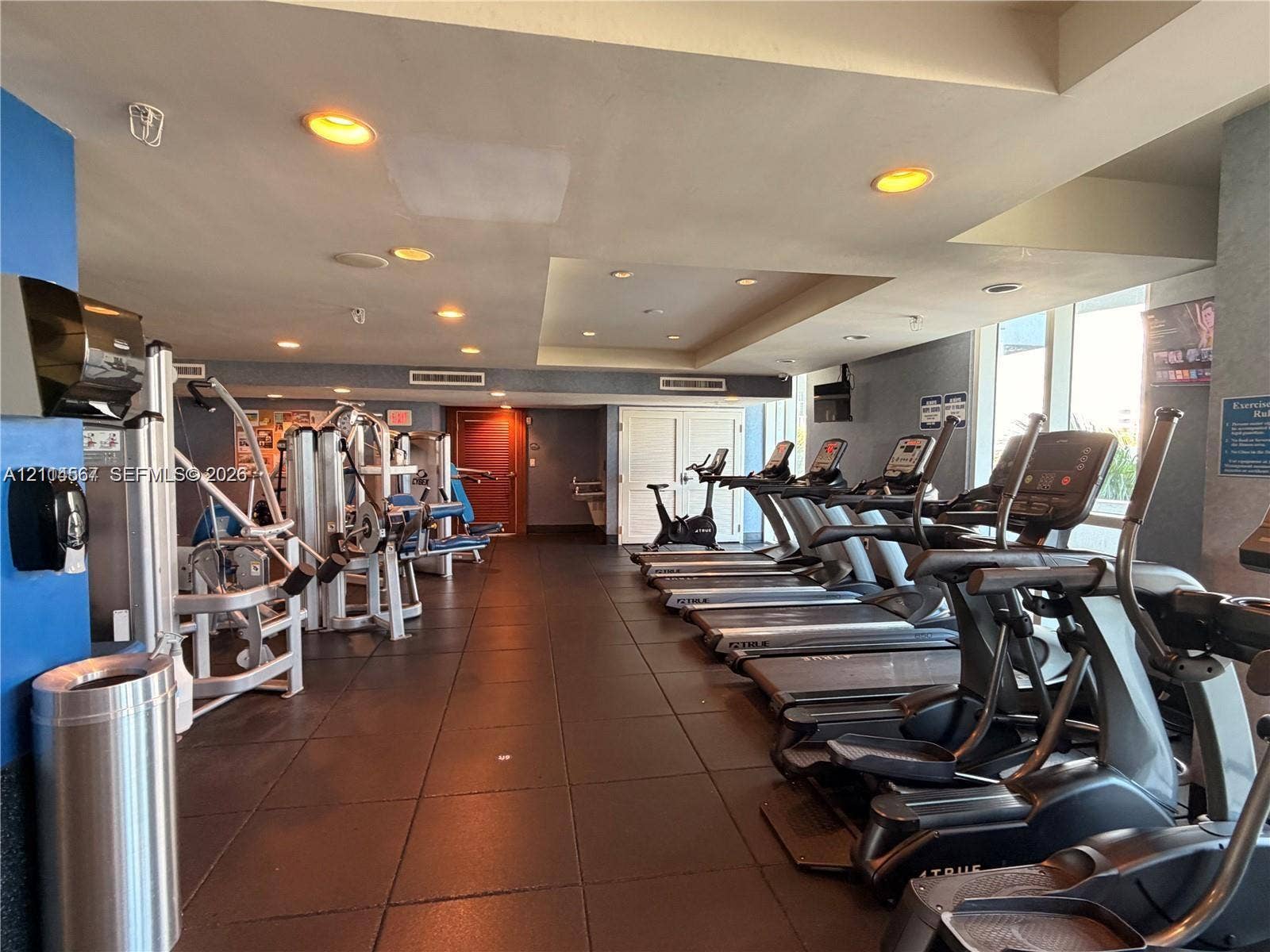 Fitness center featuring rubber flooring, recessed ceiling lighting, and floor-to-ceiling windows