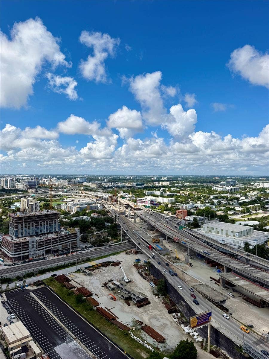 20 NE 11, #3312B, Miami, FL 33132 High-elevation aerial perspective featuring an expansive cityscape, multi-level roadway infrastructure, and integrated surface parking