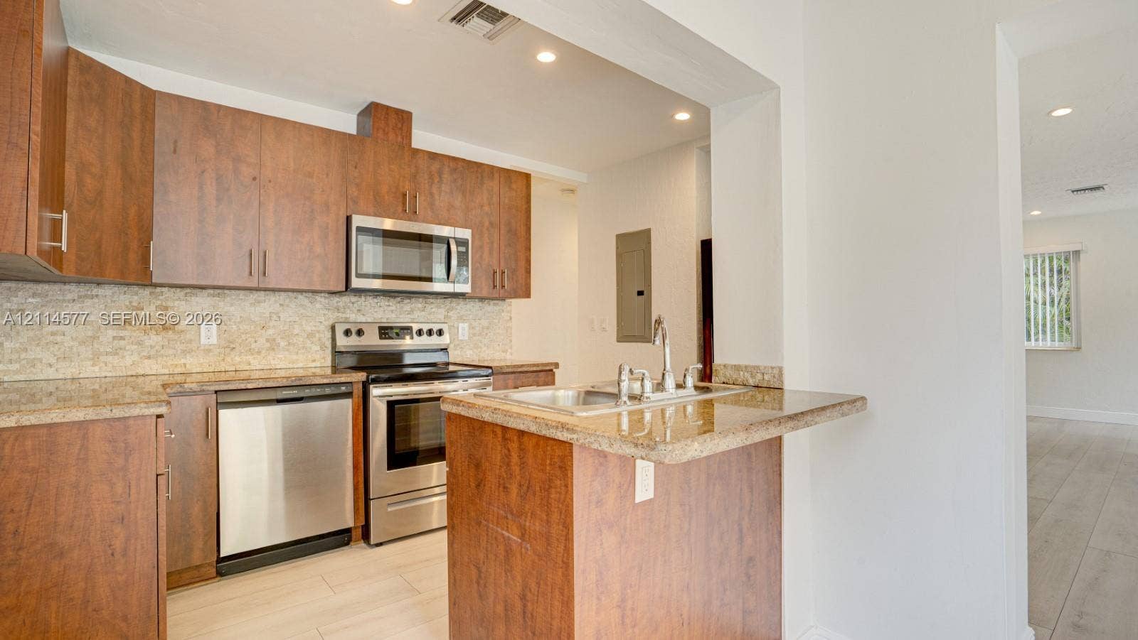 311 SW 38th Court, #0, Miami, Miami, FL 33134 Kitchen featuring flat-panel wood cabinetry, stone countertops, textured stone backsplash, stainless steel appliances, and recessed lighting