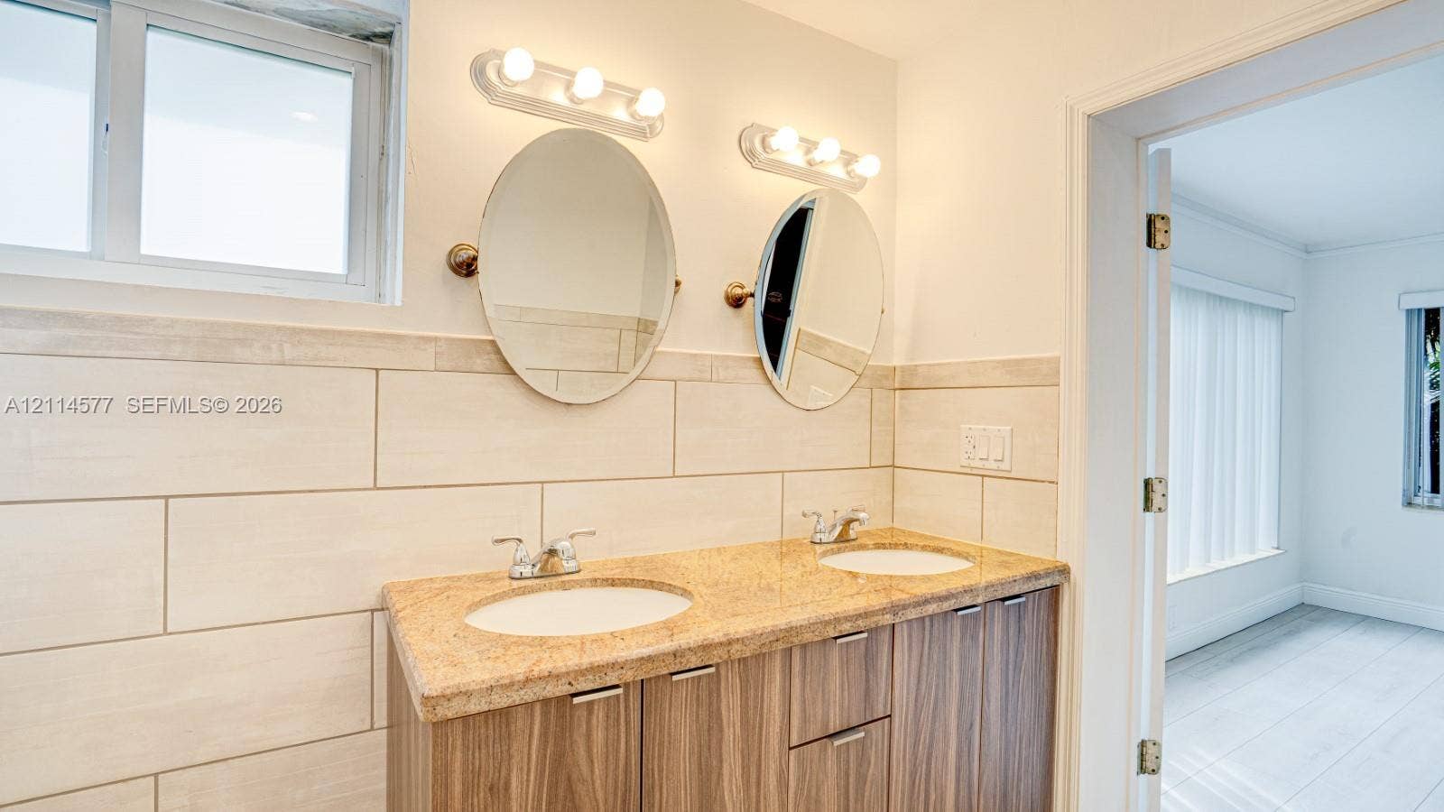 311 SW 38th Court, #0, Miami, Miami, FL 33134 Double vanity with a stone-finish countertop, dual drop-in sinks, wood-finish cabinetry, and ceramic tile wall accents