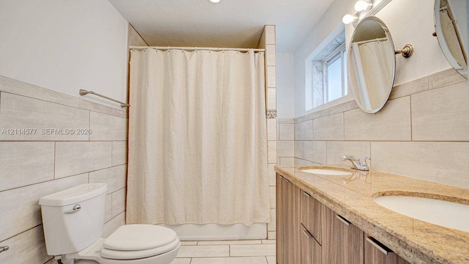 311 SW 38th Court, #0, Miami, Miami, FL 33134 Dual-sink vanity with stone-surfaced countertop, wood-finish cabinetry, ceramic tile wall cladding, and walk-in shower enclosure