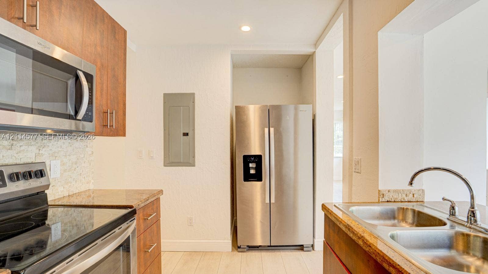 311 SW 38th Court, #0, Miami, Miami, FL 33134 Kitchen featuring flat-panel wood-finish cabinetry, stainless steel appliances, stone countertops, textured stone tile backsplash, and a double-basin stainless steel sink with a gooseneck faucet