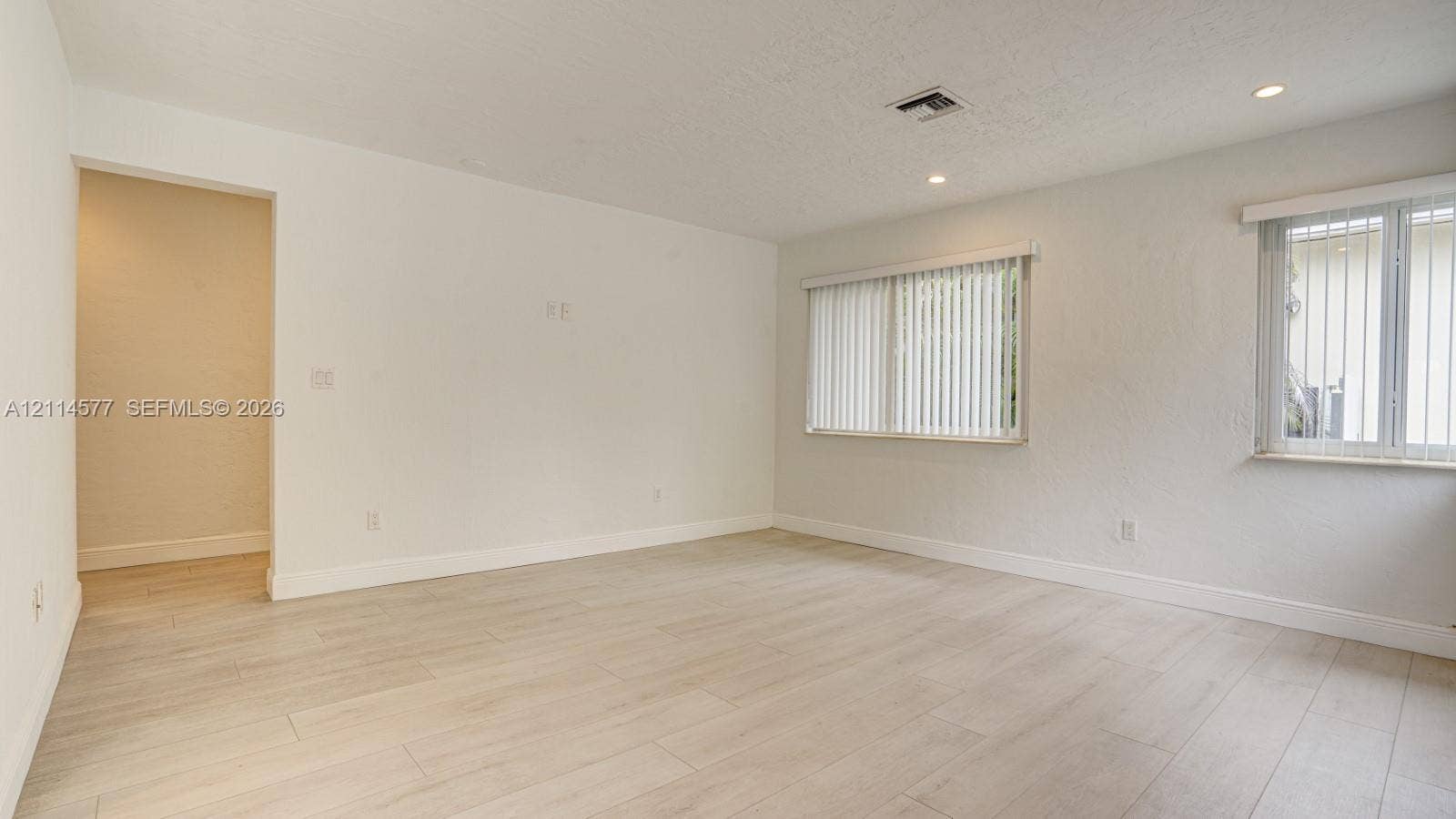 311 SW 38th Court, #0, Miami, Miami, FL 33134 Interior space featuring light-toned wood-finish flooring, recessed lighting, and dual windows with vertical blinds
