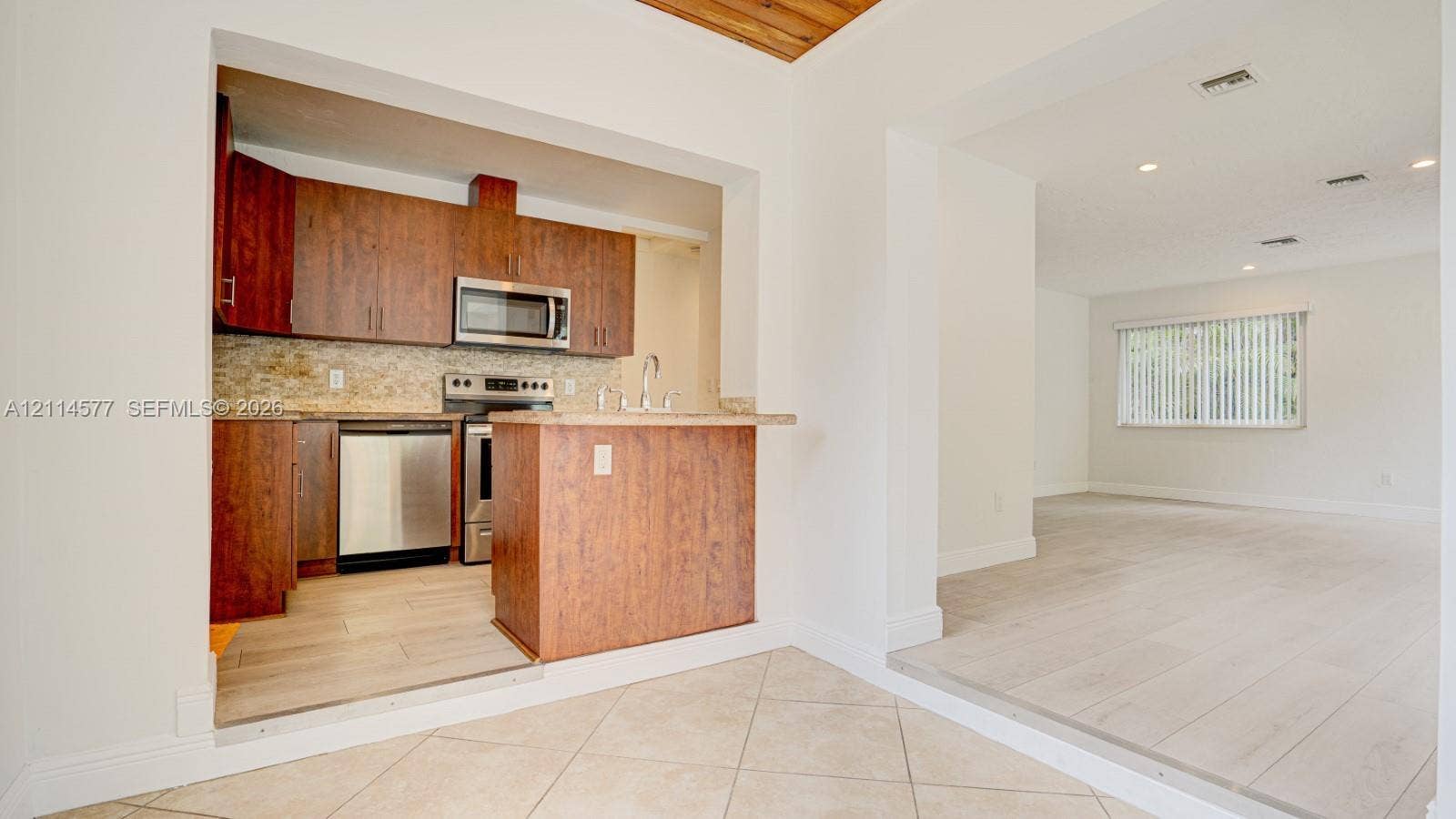 311 SW 38th Court, #0, Miami, Miami, FL 33134 Kitchen featuring wood-finish cabinetry, stainless steel appliances, tile backsplash, and wood-finish flooring with a wood-plank ceiling accent