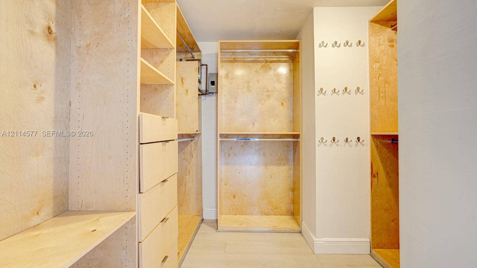311 SW 38th Court, #0, Miami, Miami, FL 33134 Custom wood-finish storage cabinetry featuring integrated drawer banks, adjustable shelving, tiered clothing rods, and wall-mounted hardware