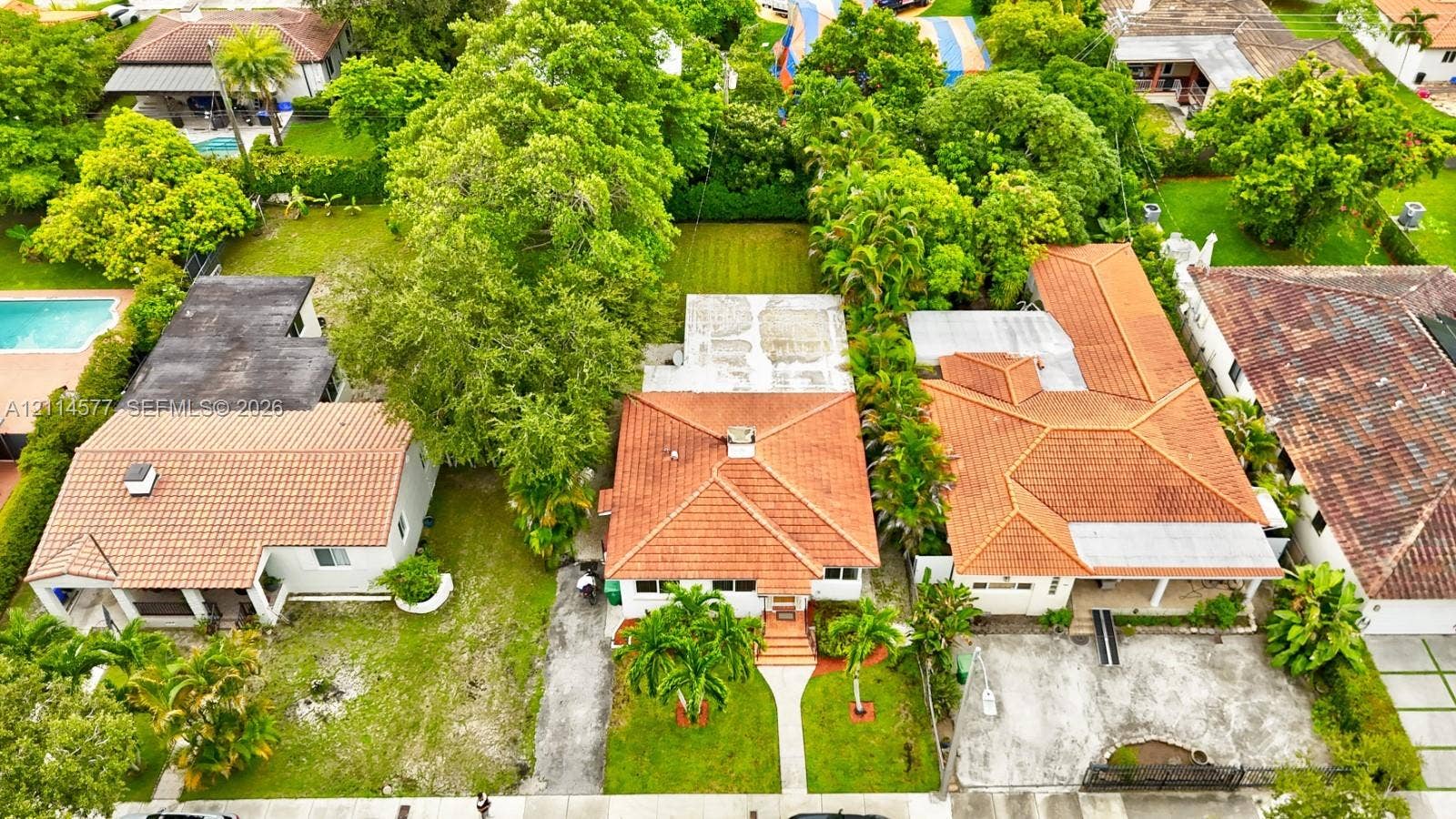 311 SW 38th Court, #0, Miami, Miami, FL 33134 Aerial perspective featuring a terracotta-tiled roofline, concrete walkway, mature landscaping, and an expansive lawn