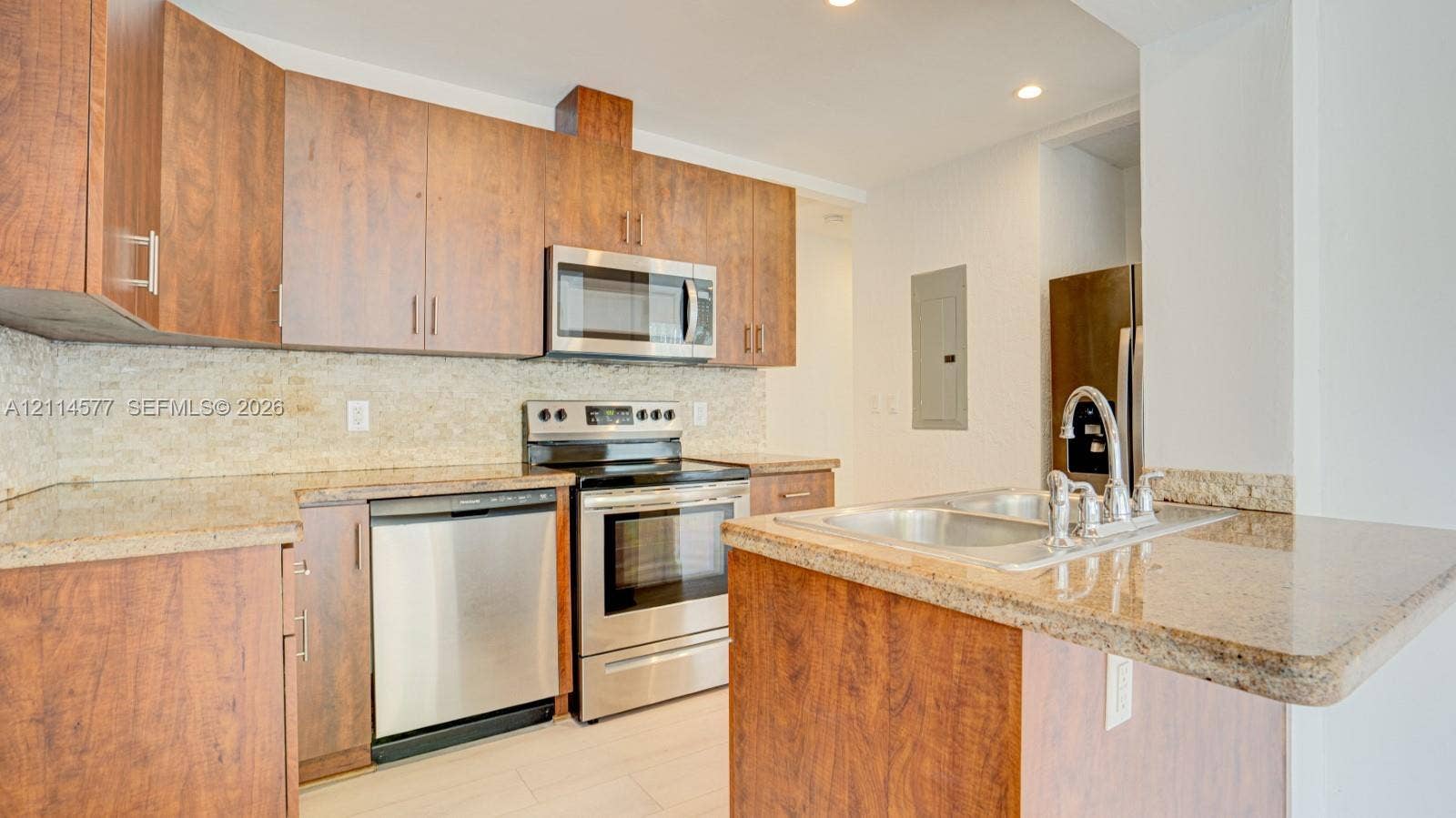 311 SW 38th Court, #0, Miami, Miami, FL 33134 Kitchen featuring wood-finish cabinetry, stone-surface countertops, stone tile backsplash, and stainless steel appliances