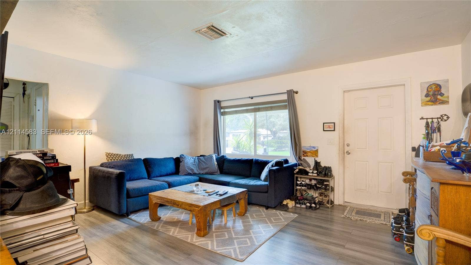 13301 NW Miami Court, Miami, FL 33168 Living area featuring wood-finish flooring, a horizontal sliding window, and a panelled entry door
