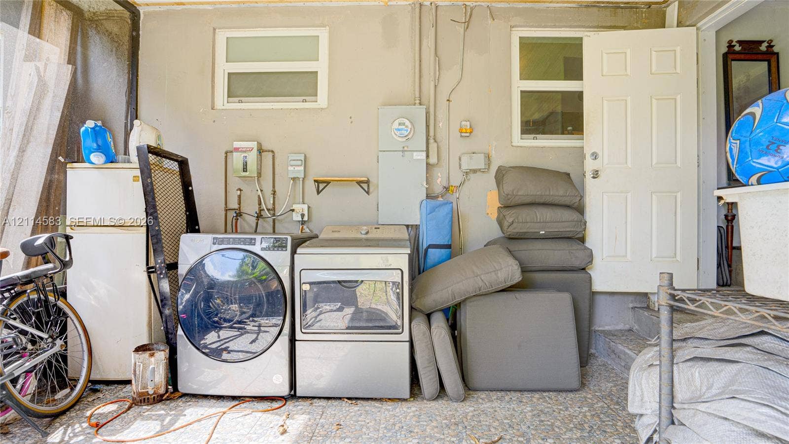 13301 NW Miami Court, Miami, FL 33168 Laundry area featuring dedicated water hookups, dual windows, and an exterior door