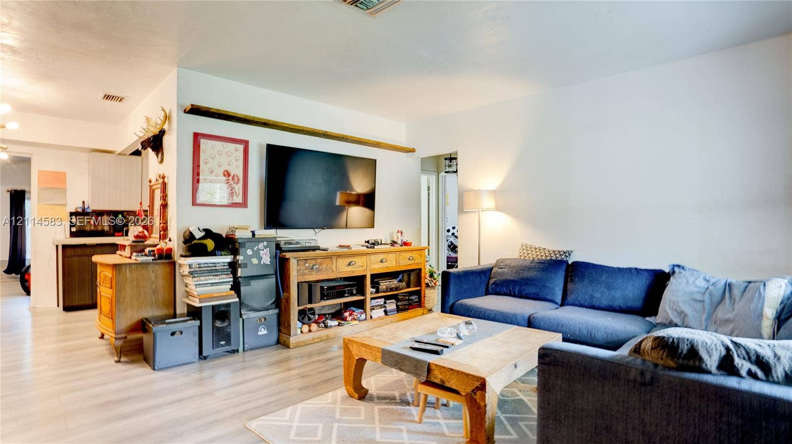 13301 NW Miami Court, Miami, FL 33168 Light-toned wood-finish flooring and a prominent horizontal wooden wall accent beam
