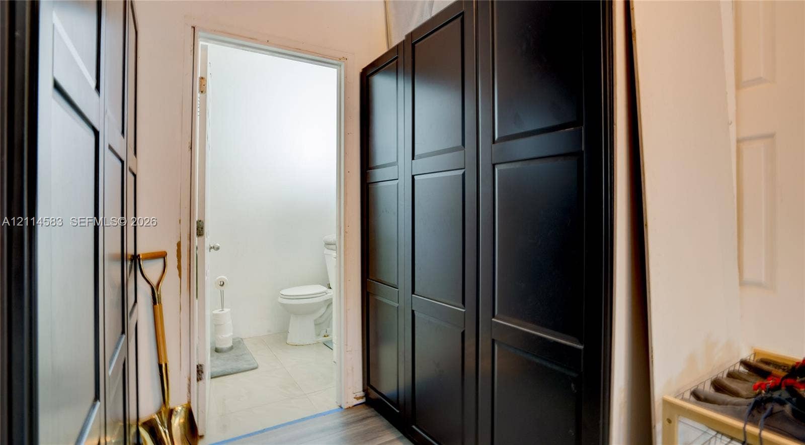 13301 NW Miami Court, Miami, FL 33168 Custom built-in black cabinetry with recessed panel doors and wood-finish flooring