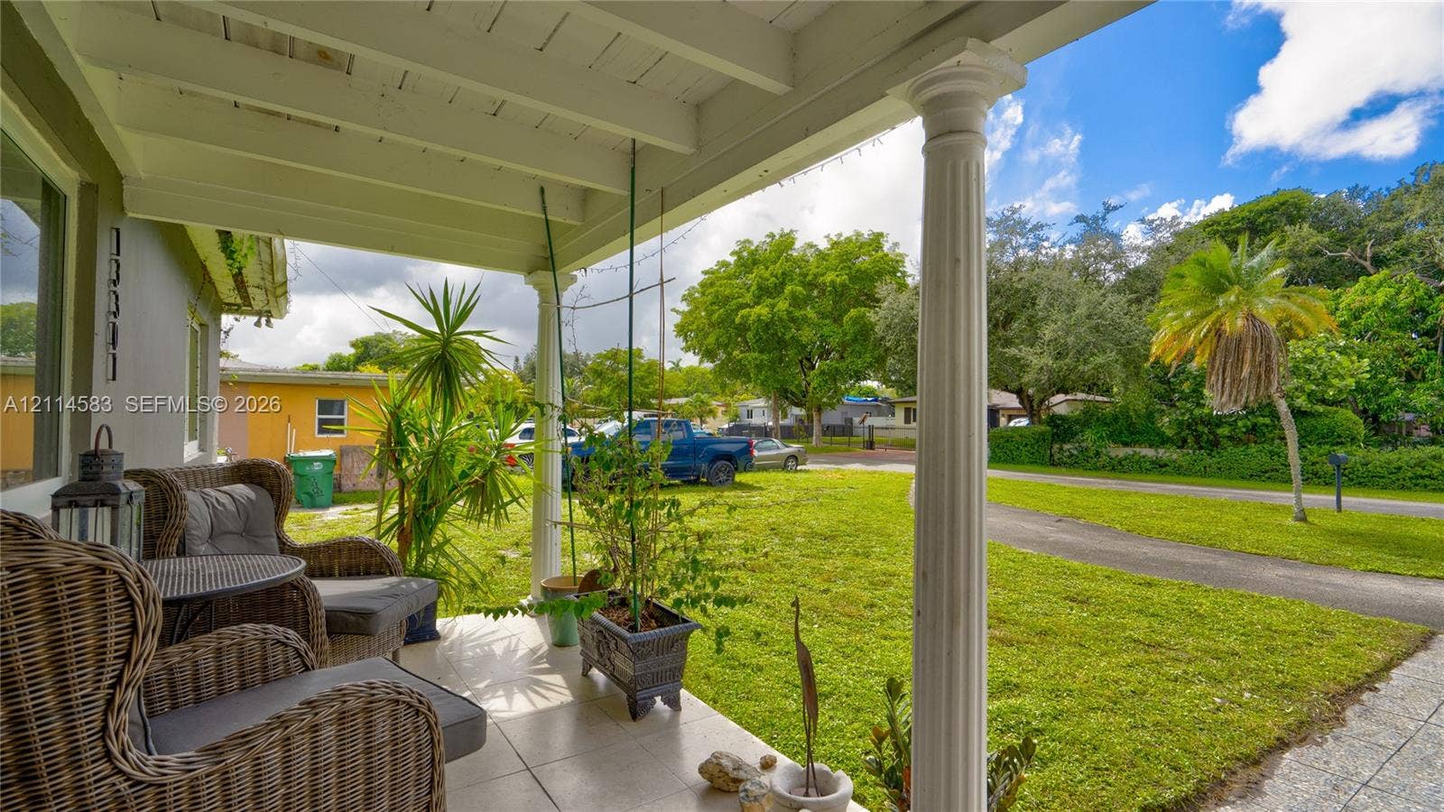 13301 NW Miami Court, Miami, FL 33168 Covered front porch featuring tile flooring, structural columns, and exposed rafter ceiling design