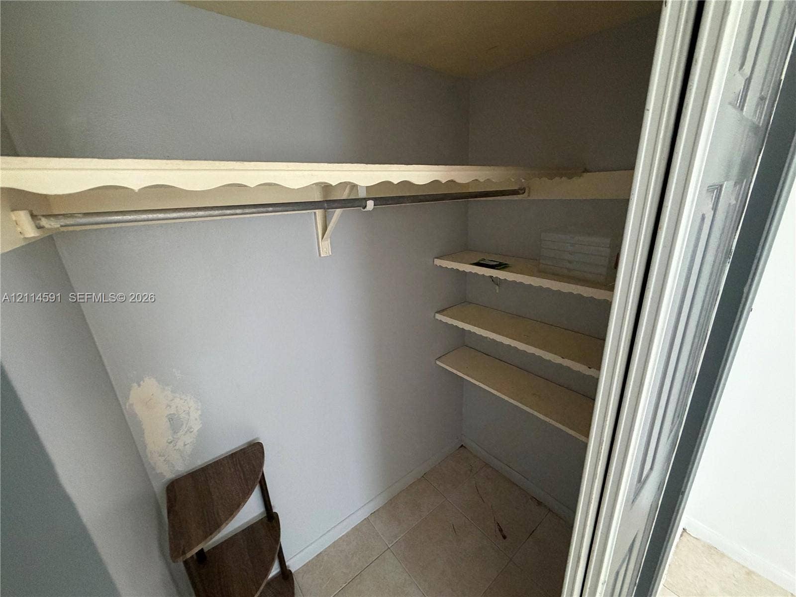 Closet featuring tile flooring, a built-in rod, and multi-tiered shelving