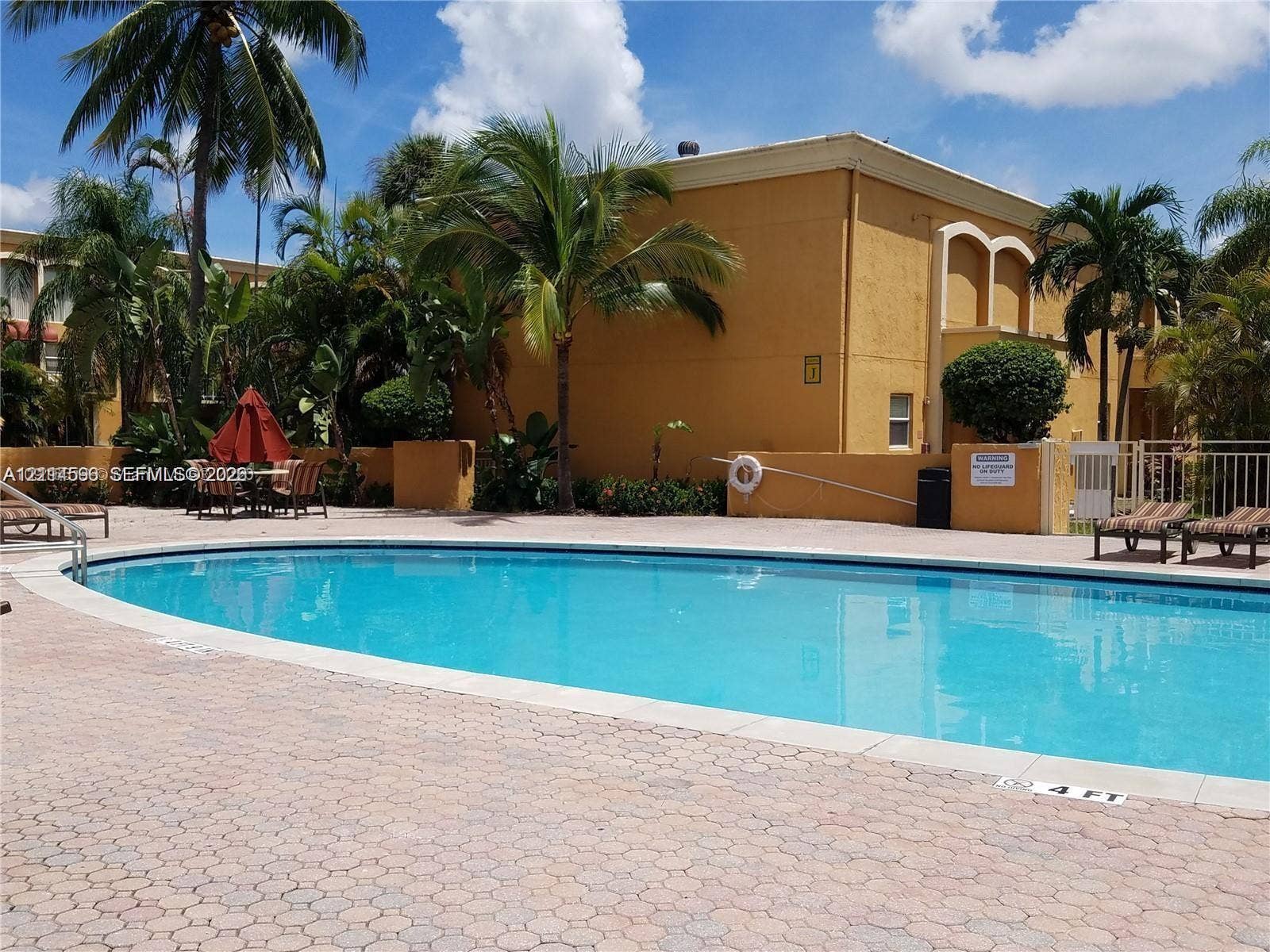 17901 NW 68th Avenue, #R202, Hialeah, Hialeah, FL 33015 Swimming pool with a brick-paver deck and surrounding palm trees