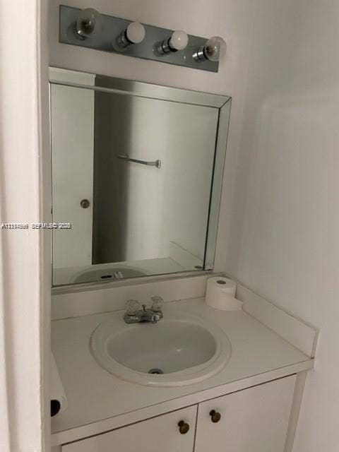 17901 NW 68th Avenue, #R202, Hialeah, Hialeah, FL 33015 Built-in vanity featuring a white countertop with an integrated basin, four-light wall-mounted vanity fixture, and a square beveled-edge mirror