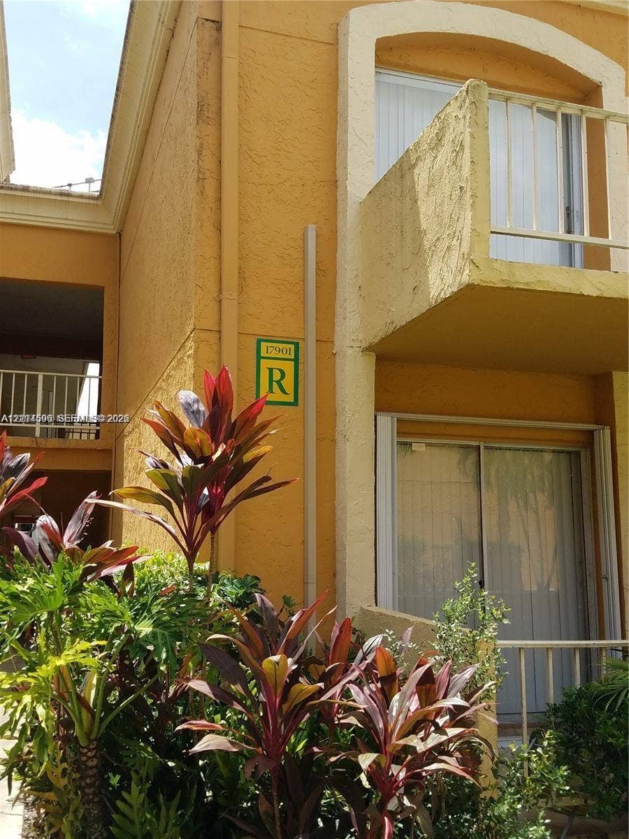17901 NW 68th Avenue, #R202, Hialeah, Hialeah, FL 33015 Stucco exterior featuring a second-story balcony with metal railings and sliding glass doors