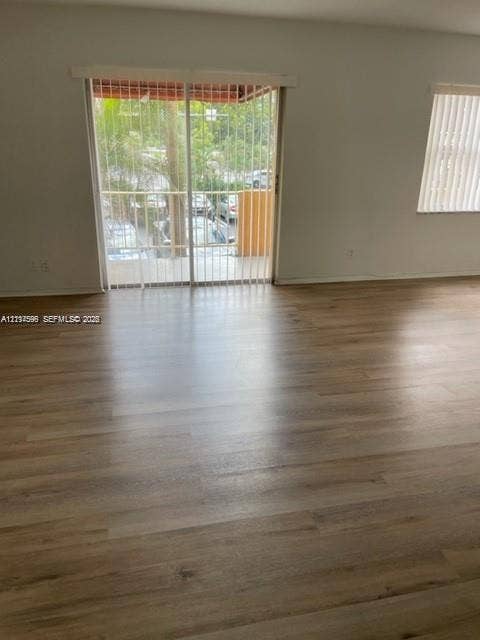 17901 NW 68th Avenue, #R202, Hialeah, Hialeah, FL 33015 Wood-finish flooring, sliding glass patio door, and vertical window blinds