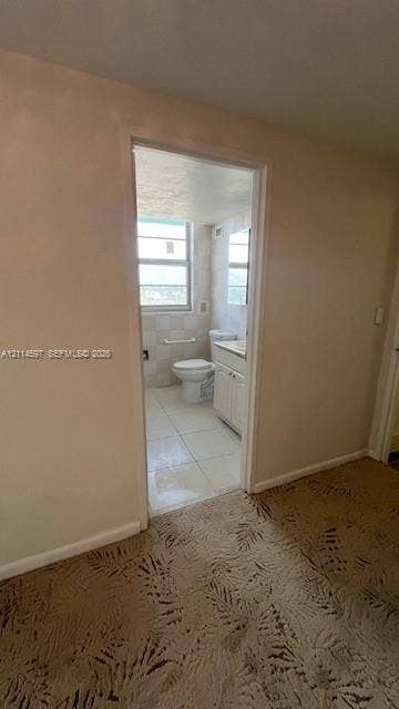 5255 Collins Avenue, #5J, Miami Beach, Miami Beach, FL 33140 Bathroom featuring tile flooring, a built-in vanity cabinet with countertop, an integrated commode, and a window with a horizontal grid pattern