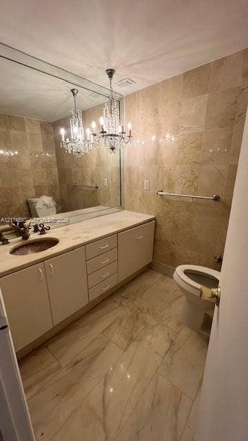 5255 Collins Avenue, #5J, Miami Beach, Miami Beach, FL 33140 Bathroom featuring full-wall tile surround, vanity with inset sink and stone countertop, large-format tiled flooring, and a decorative crystal chandelier