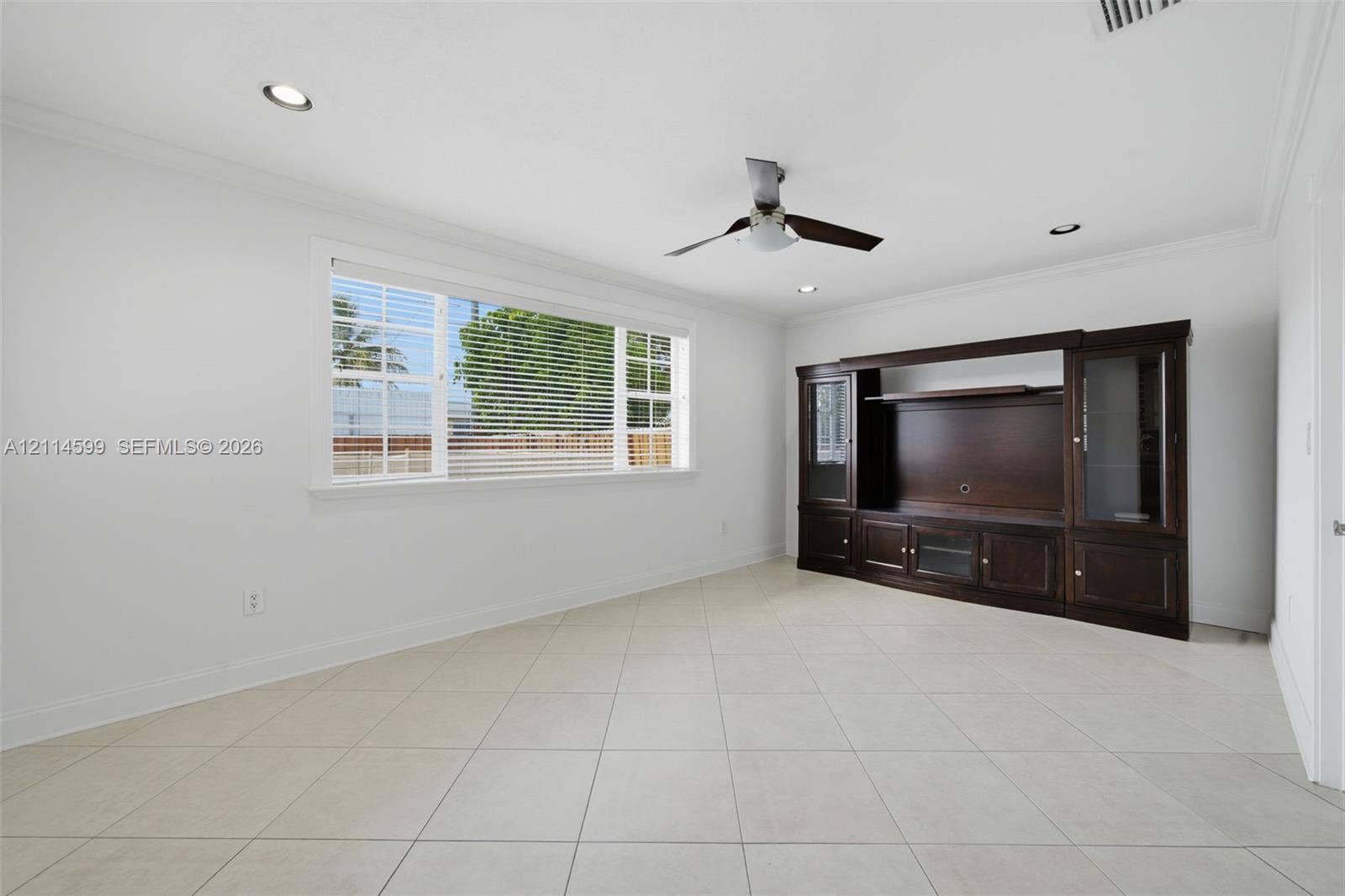 Tile flooring, recessed lighting, ceiling fan, and built-in dark wood cabinetry