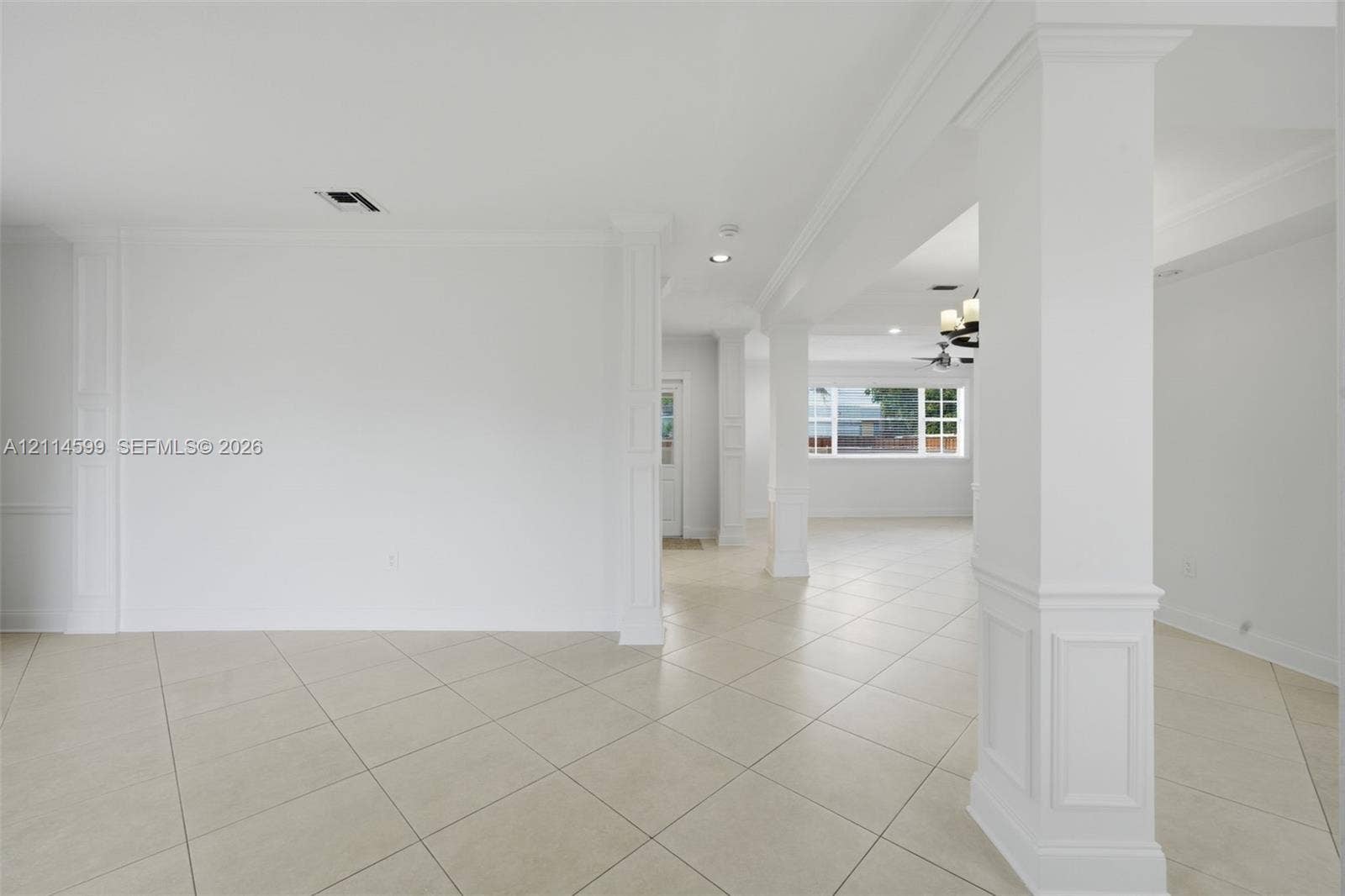 Interior space featuring large-format diagonal tile flooring, custom millwork on structural columns, recessed lighting, and multi-pane windows