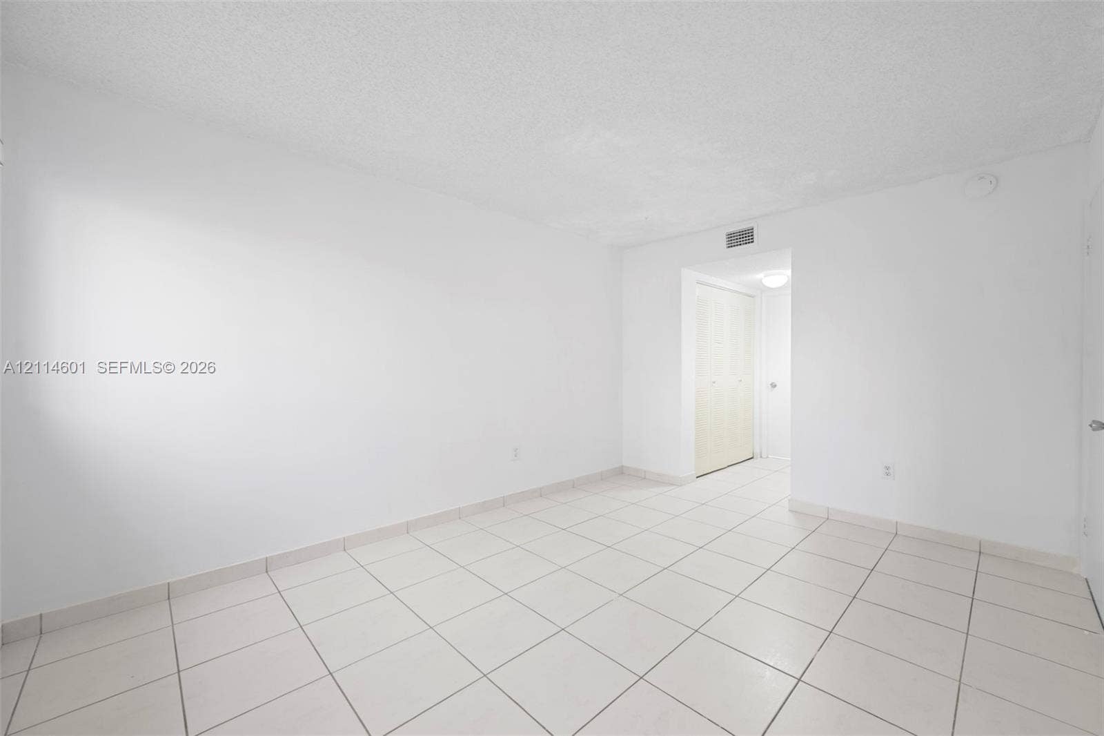 6801 Harding Avenue, #311, Miami Beach, Miami Beach, FL 33141 Neutral interior featuring large-format ceramic floor tiling and a built-in closet with bi-fold doors