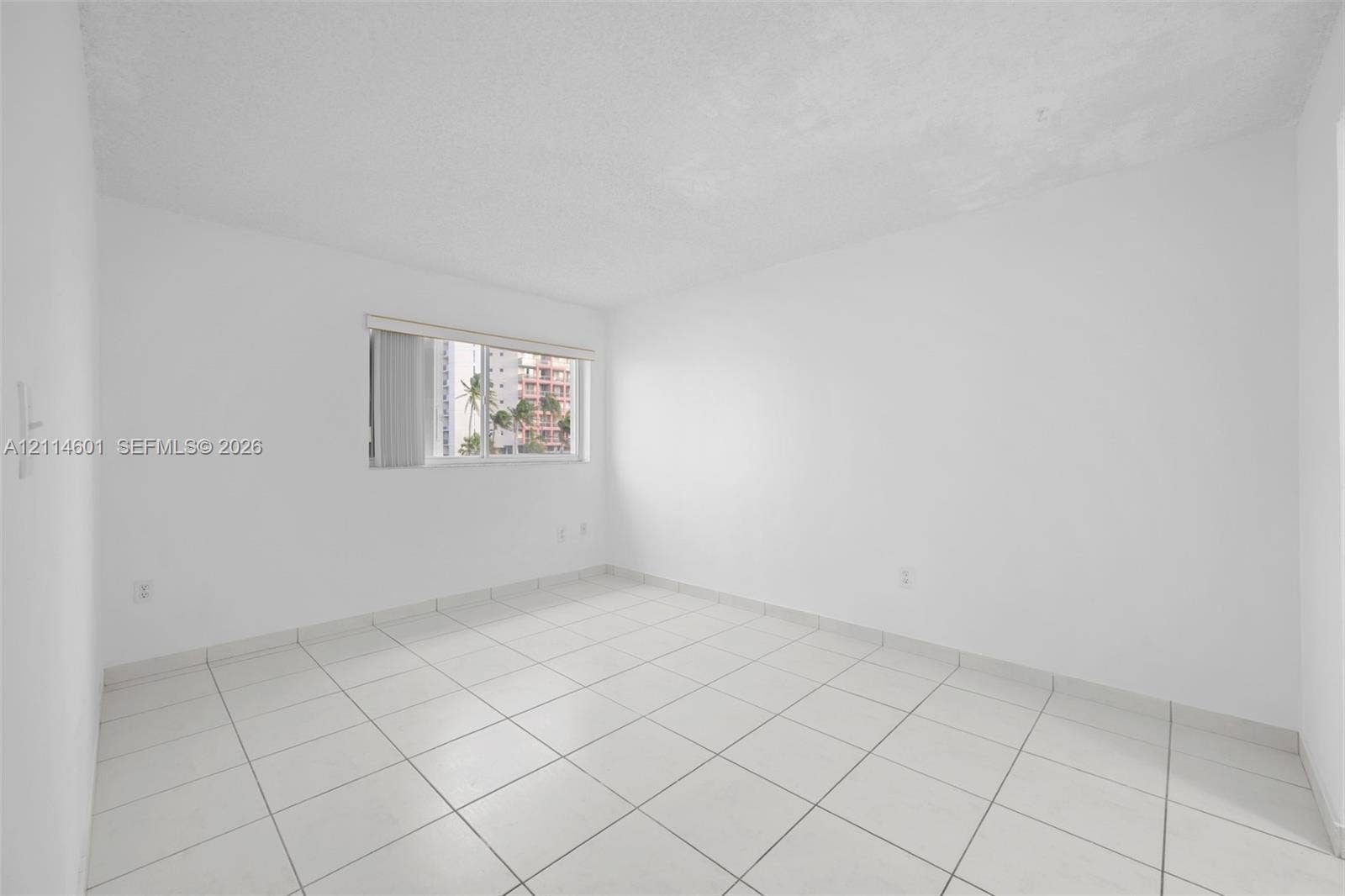 6801 Harding Avenue, #311, Miami Beach, Miami Beach, FL 33141 Neutral room featuring white walls, square tile flooring, and a single-pane window with adjustable blinds