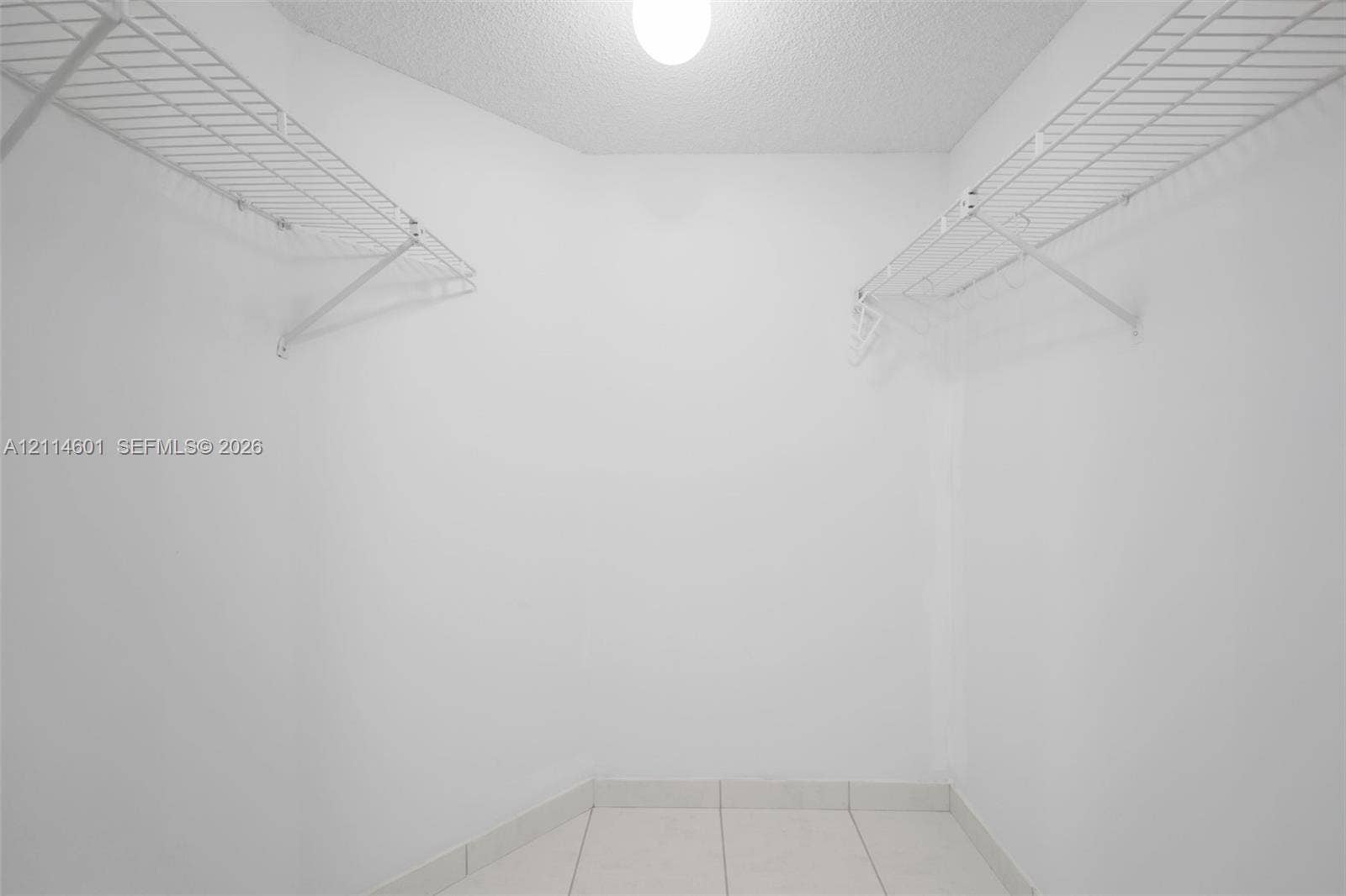 6801 Harding Avenue, #311, Miami Beach, Miami Beach, FL 33141 Storage area featuring white walls, white tile flooring, and dual tiers of white wire shelving