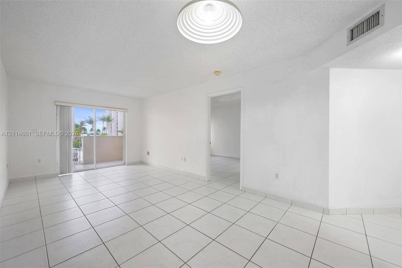 6801 Harding Avenue, #311, Miami Beach, Miami Beach, FL 33141 Interior space featuring large-format ceramic floor tiles, recessed ceiling lighting, and sliding glass doors with exterior patio access