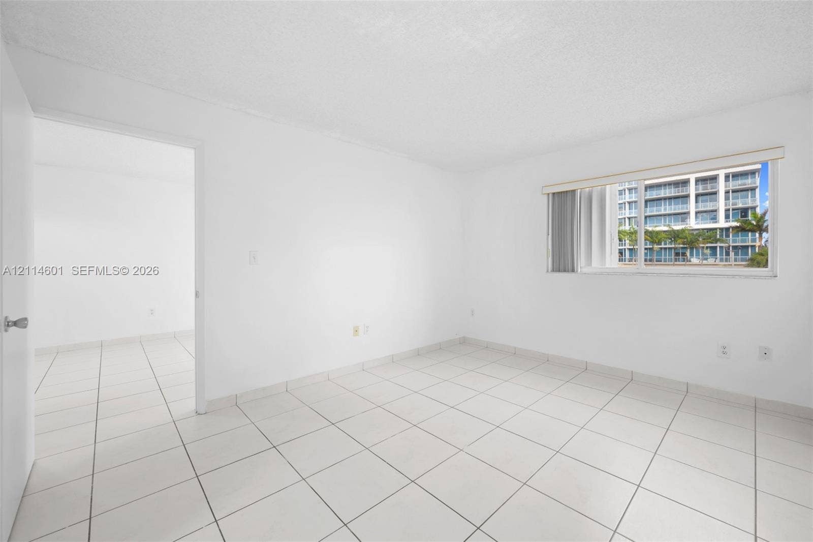 6801 Harding Avenue, #311, Miami Beach, Miami Beach, FL 33141 Interior room featuring neutral wall finishes, tile flooring, and a sliding glass window