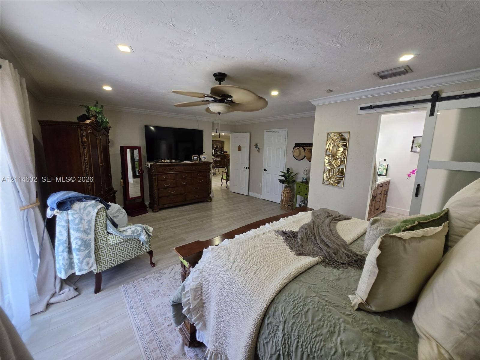 8450 NW 178th Street, Hialeah, Hialeah, FL 33015 Wood-finish flooring, recessed lighting, ceiling fan with light fixture, and sliding barn-style door