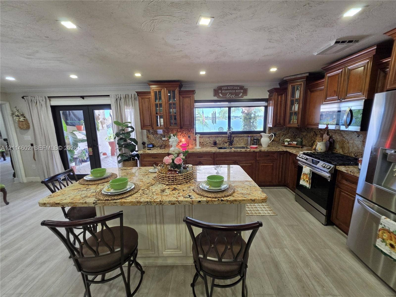 8450 NW 178th Street, Hialeah, Hialeah, FL 33015 Kitchen featuring stained wood cabinetry, stone countertops, a central island with integrated seating space, recessed lighting, and stainless steel appliances