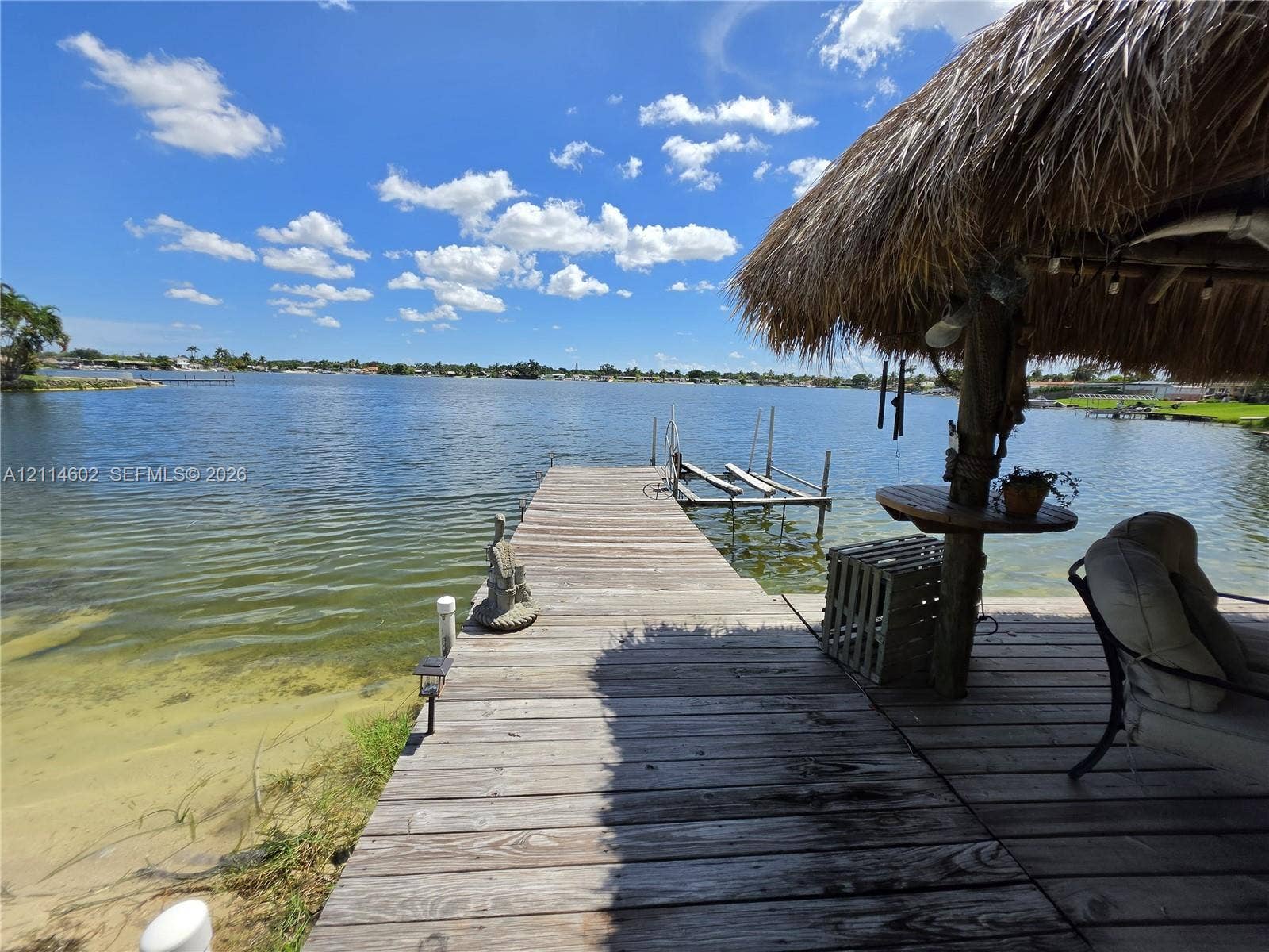8450 NW 178th Street, Hialeah, Hialeah, FL 33015 Waterfront property featuring a wooden dock, a thatch-roofed gazebo, and a built-in boat lift