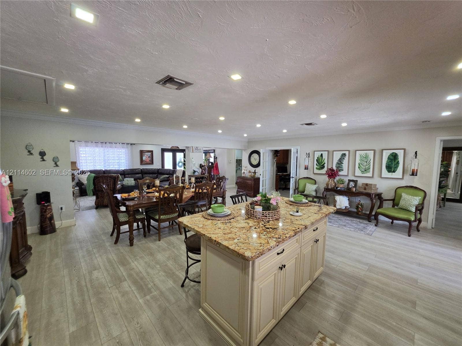 8450 NW 178th Street, Hialeah, Hialeah, FL 33015 Kitchen featuring an expansive stone-topped island with shaker-style cabinetry, recessed ceiling lighting, and wood-finish flooring throughout
