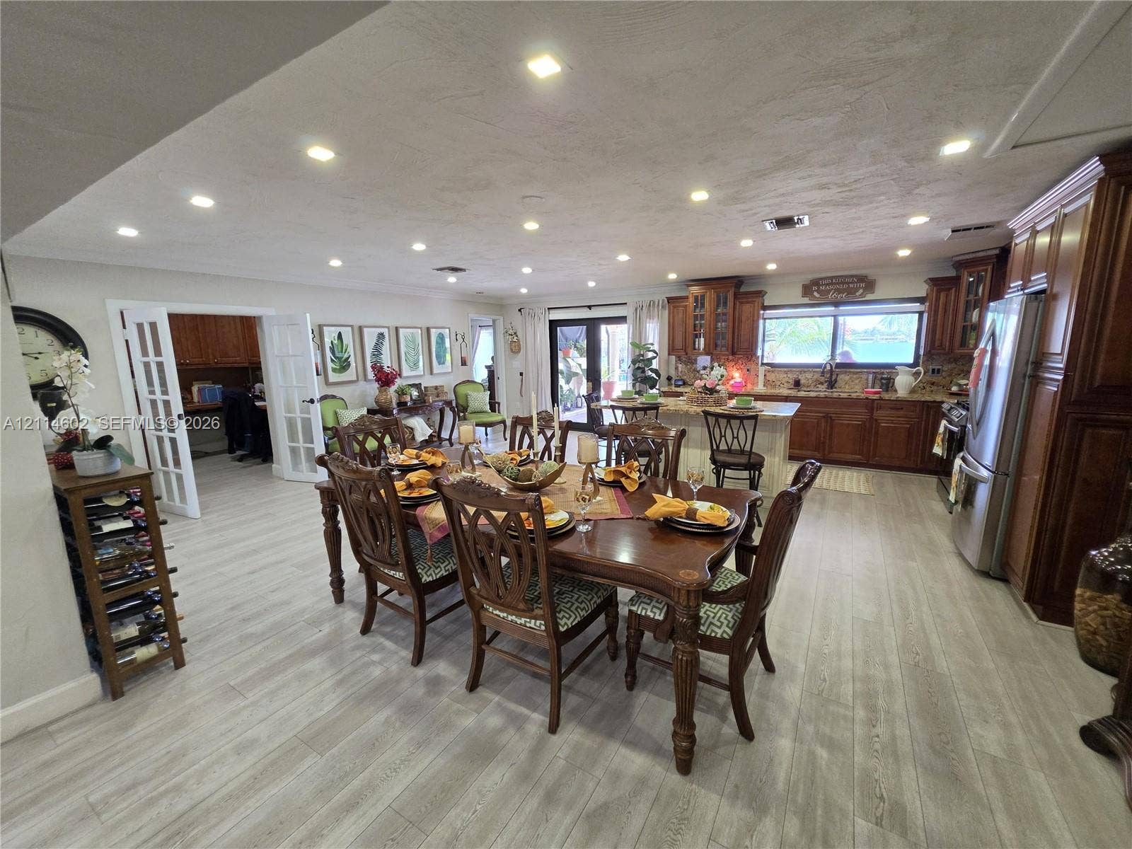 8450 NW 178th Street, Hialeah, Hialeah, FL 33015 Open-concept kitchen and dining area featuring wood-finish flooring, recessed lighting, stained wood cabinetry, a center island, and French doors