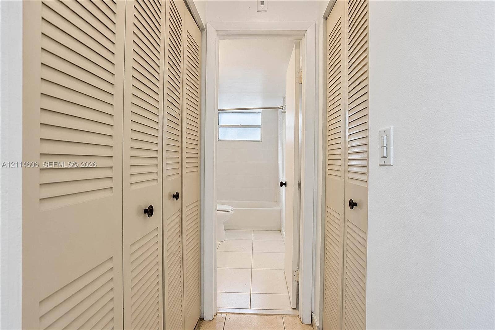 14155 SW 87th Street, #404-E, Miami, FL 33183 Floor-to-ceiling bi-fold louvered closet doors and tile flooring