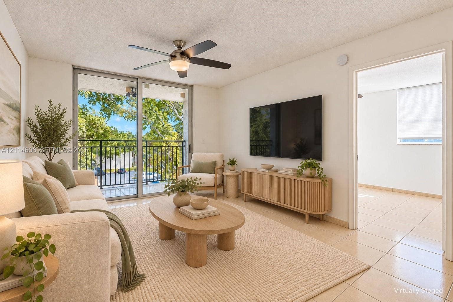 14155 SW 87th Street, #404-E, Miami, FL 33183 Living area featuring tile flooring, ceiling fan with integrated lighting, and a sliding glass door providing access to a balcony with metal railings