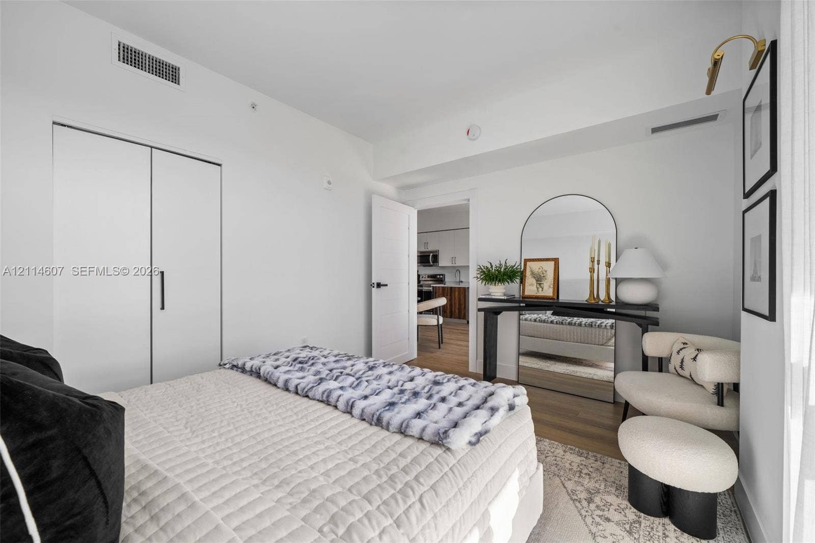2479 NE 192nd Street, #103, Miami, Miami, FL 33180 Room featuring wood-finish flooring, white walls, and a closet with black hardware
