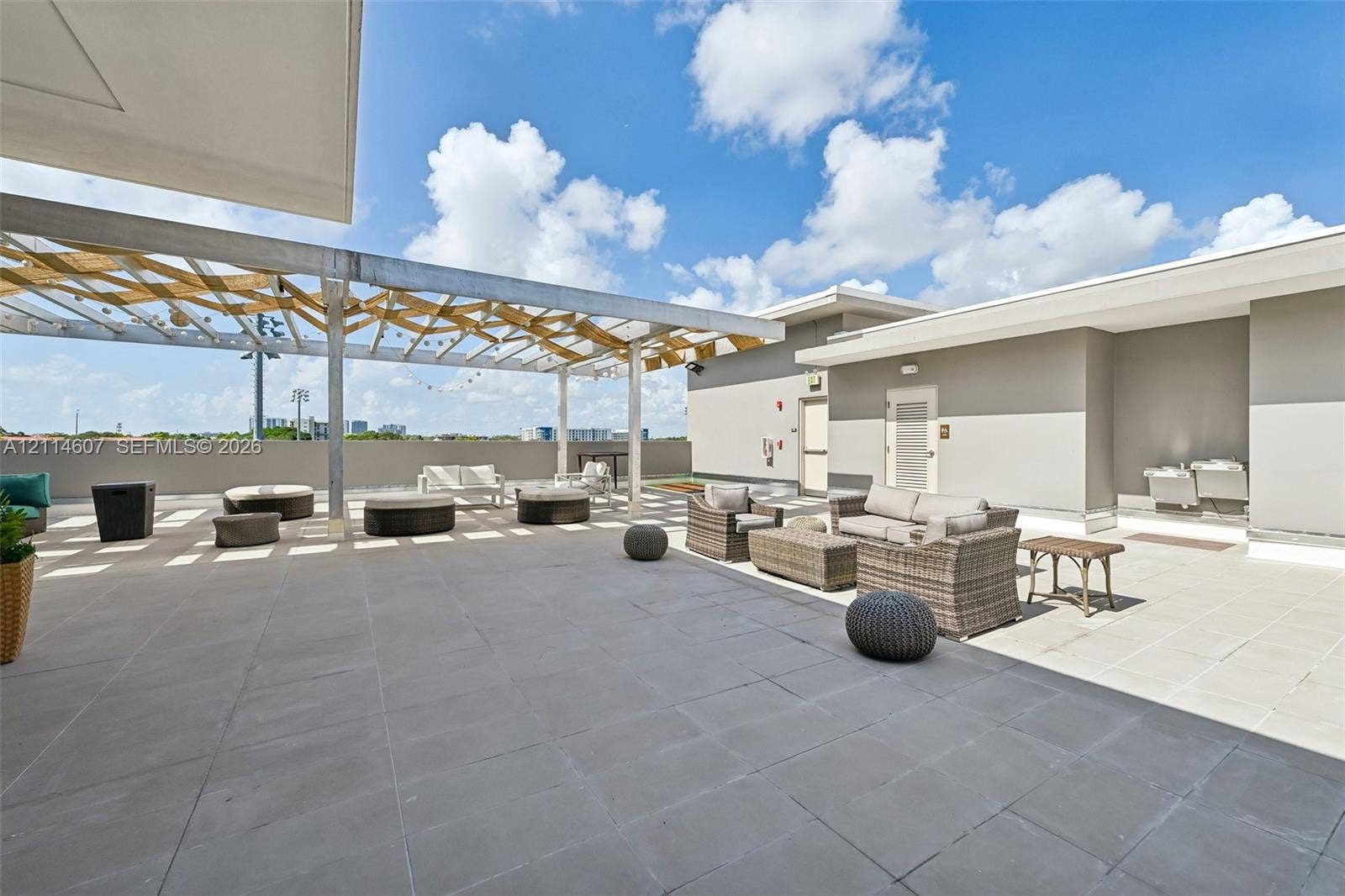 2479 NE 192nd Street, #103, Miami, Miami, FL 33180 Expansive rooftop terrace featuring large-format tile flooring and a structural wooden pergola