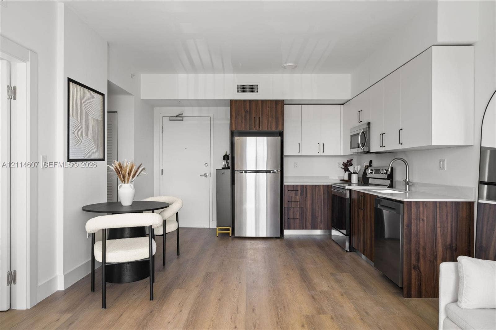 2479 NE 192nd Street, #103, Miami, Miami, FL 33180 Kitchen featuring flat-panel two-tone cabinetry, quartz countertops, stainless steel appliances, wood-finish flooring, and high-arc faucet