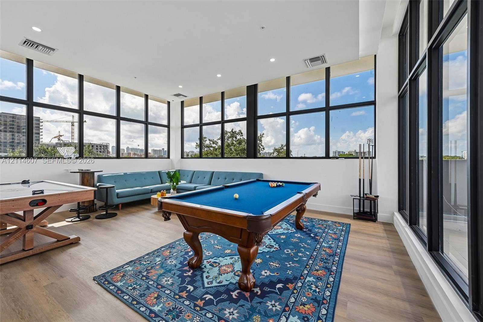 2479 NE 192nd Street, #103, Miami, Miami, FL 33180 Expansive room featuring floor-to-ceiling windows with black frames, wood-finish flooring, and recessed ceiling lighting