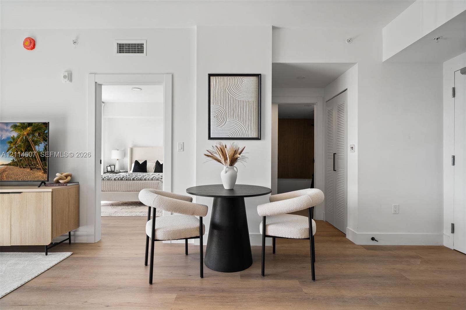 2479 NE 192nd Street, #103, Miami, Miami, FL 33180 Open-concept interior featuring light wood-finish flooring, crisp white walls, and a dedicated utility closet with louvered doors